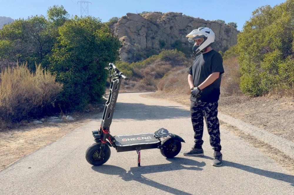 Rider with ONECNA electric scooter wearing a helmet on a road