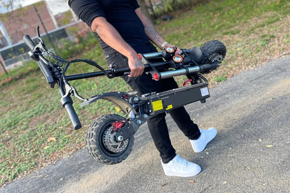 Person carrying a folded ONECNA electric scooter — how to fold and carry your electric scooter efficiently